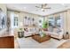 Spacious living room with two sofas, large windows, ceiling fan, and neutral decor at 1003 Cloud Ridge Ct, Mount Dora, FL 32757