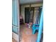 Covered porch area with tile flooring, a blue chair, cat tree, and slider looking to the outside at 135 Pine Island Cir, Kissimmee, FL 34743