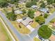 An aerial view shows a home with a screened-in pool, patio, shed, landscaping, and mature trees at 1594 Frances St, Kissimmee, FL 34744