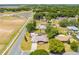 An aerial view shows a home with a screened-in pool, patio, shed, landscaping, and mature trees at 1594 Frances St, Kissimmee, FL 34744