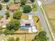 An aerial view shows a home with a screened-in pool, patio, shed, landscaping, and mature trees at 1594 Frances St, Kissimmee, FL 34744
