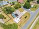 An aerial view shows a home with a screened-in pool, patio, shed, and landscaping at 1594 Frances St, Kissimmee, FL 34744