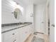 Bathroom with stone countertops, tile flooring, white cabinets, and a stylish round mirror at 1594 Frances St, Kissimmee, FL 34744