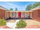 Charming front porch with red columns, a decorative red door, and manicured landscaping at 1594 Frances St, Kissimmee, FL 34744
