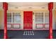 Close-up of the inviting front porch with red columns and a decorative door, adding character at 1594 Frances St, Kissimmee, FL 34744