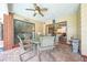 View of the outdoor patio featuring a glass table and four chairs, and ceiling fan above at 1594 Frances St, Kissimmee, FL 34744