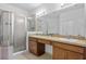 Bright bathroom featuring double sinks, granite countertops, and glass shower enclosure at 1809 Portofino Meadows Blvd, Orlando, FL 32824