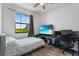 Bedroom featuring a bed, desk, chair, and a window offering natural light and neighborhood views at 1809 Portofino Meadows Blvd, Orlando, FL 32824