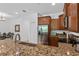 Modern kitchen featuring granite countertops, stainless steel appliances, and brown wood cabinetry at 1809 Portofino Meadows Blvd, Orlando, FL 32824