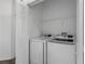 Well-equipped laundry room with a new, modern white washer and dryer set and overhead shelving for storage at 1809 Portofino Meadows Blvd, Orlando, FL 32824