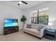 Living room featuring a cozy couch, a large window with blinds, and a TV stand with beach decor at 1809 Portofino Meadows Blvd, Orlando, FL 32824