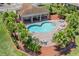 Kidney-shaped community pool and sundeck surrounded by lush landscaping and shaded by a covered pavilion at 1809 Portofino Meadows Blvd, Orlando, FL 32824