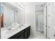 Bright bathroom featuring double sink vanity with white countertops and tiled floor and glass door shower at 1817 Caribbean View Ter, Kissimmee, FL 34747