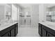 Bright bathroom featuring double vanities, a glass-enclosed shower, and stylish fixtures at 1817 Caribbean View Ter, Kissimmee, FL 34747