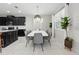 Contemporary dining area with black cabinets and a modern white table illuminated by a decorative pendant light at 1817 Caribbean View Ter, Kissimmee, FL 34747