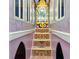 Hallway designed as interior of castle tower featuring colorful steps and a chandelier at 1817 Caribbean View Ter, Kissimmee, FL 34747