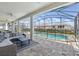 Screened-in patio area with couches and a coffee table, overlooking the pool and backyard at 1817 Caribbean View Ter, Kissimmee, FL 34747