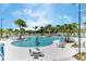 Resort style community pool with tables and chairs surrounded by palm trees at 1817 Caribbean View Ter, Kissimmee, FL 34747