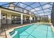 Resort-style backyard features a screened-in pool and spa, ample seating, and a covered patio for relaxation at 1817 Caribbean View Ter, Kissimmee, FL 34747