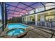 Backyard pool and hot tub surrounded by a screened enclosure at sunset at 1817 Caribbean View Ter, Kissimmee, FL 34747