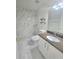 Modern bathroom with marble shower, granite countertop, and sleek white cabinets at 1960 Aspenridge Ct, Ocoee, FL 34761