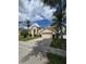 Two-story home featuring a two-car garage, arched entryway, and lush green front lawn at 1960 Aspenridge Ct, Ocoee, FL 34761