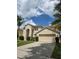 Two-story home featuring a two-car garage, arched entryway, and a well-maintained lawn at 1960 Aspenridge Ct, Ocoee, FL 34761