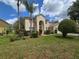 Two-story home featuring an arched entryway, lush green front lawn, and meticulously maintained landscaping at 1960 Aspenridge Ct, Ocoee, FL 34761