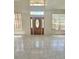 Bright living room with tile flooring, large windows, and a decorative front door at 1960 Aspenridge Ct, Ocoee, FL 34761