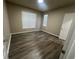 Bright bedroom showcasing wood-look flooring, two large windows, and neutral paint at 19935 Villa Isle Dr # 107, Orlando, FL 32821