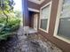 The exterior features a brown stucco wall with two windows and a white door, complemented by lush landscaping at 19935 Villa Isle Dr # 107, Orlando, FL 32821