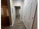 Hallway with wood-look flooring, closet doors, and an open doorway to another room at 19935 Villa Isle Dr # 107, Orlando, FL 32821