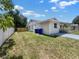 View of backyard and side of home with trash receptacles, white vinyl fencing, and new wooden fencing at 2317 10Th St, St Cloud, FL 34769