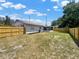 View of the spacious backyard featuring a new wooden fence, fresh landscaping, and screened-in lanai at 2317 10Th St, St Cloud, FL 34769