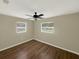 Cozy bedroom with two windows, ceiling fan, and wood-look flooring at 2317 10Th St, St Cloud, FL 34769