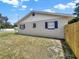 View of home's exterior with blue shutters, a well maintained lawn, and a newly constructed wood fence at 2317 10Th St, St Cloud, FL 34769