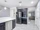 Modern kitchen features stainless steel appliances, black cabinetry and tile flooring at 238 Granada Ave, Davenport, FL 33837