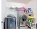 A fully equipped laundry room with modern washer and dryer, plus shelving for storage and organization at 238 Granada Ave, Davenport, FL 33837