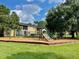 Community playground with new equipment surrounded by green grass at 2408 Barley Club Ct # 2, Orlando, FL 32837