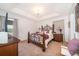 Bright bedroom with a tray ceiling, a wrought iron bed, and neutral walls at 2462 Hassonite St, Kissimmee, FL 34744