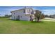 Exterior side view of townhome with a large lawn and landscaping at 2462 Hassonite St, Kissimmee, FL 34744