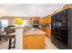Functional kitchen with wood cabinetry, black appliances, and a breakfast bar for casual dining at 2462 Hassonite St, Kissimmee, FL 34744