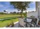 Relaxing patio with a table and chairs overlooking a large grassy area and mature trees, perfect for outdoor enjoyment at 2462 Hassonite St, Kissimmee, FL 34744