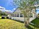 Exterior view of the home featuring lawn, sun room, and some backyard features at 2511 Balmoral Dr, Kissimmee, FL 34744