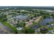 Aerial view of a waterfront community with a lake, waterway access, and several pools at 2662 Emerald Lake Ct, Kissimmee, FL 34744
