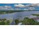 Aerial view of a large lake with trees, homes, and a community pool surrounded by lounge chairs at 2662 Emerald Lake Ct, Kissimmee, FL 34744