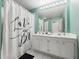 Bathroom with a double vanity, white cabinetry, a decorative shower curtain and a teal painted wall at 2662 Emerald Lake Ct, Kissimmee, FL 34744