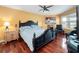 Warm bedroom featuring a dark wood bed frame, hardwood floors, and soft natural light at 2662 Emerald Lake Ct, Kissimmee, FL 34744