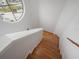 Staircase with wood floors and a bright round window; railing on the right side at 2662 Emerald Lake Ct, Kissimmee, FL 34744