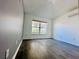 Bright bedroom with large window, and gray wood-look flooring at 2663 Oneida Loop, Kissimmee, FL 34747